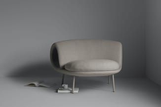 Grijsbeige fauteuil met afgeronde vormen, gebogen rugleuning en houten poten in minimalistisch interieur met boeken.