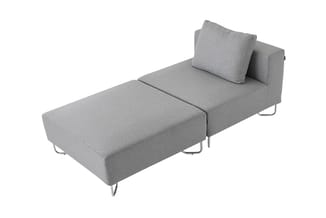 Grijze modulaire bank met chaise longue, metalen poten, kussens en armleuning aan één zijde.