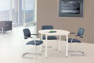 Ronde witte vergadertafel met vier grijsblauwe kantoorstoel met chromen frame in moderne kantoorruimte met raamfront.