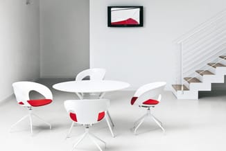 Moderne vergaderruimte met ronde witte tafel, vier witte stoelen met rode zittingen, trap en abstract rood artwork aan de muu