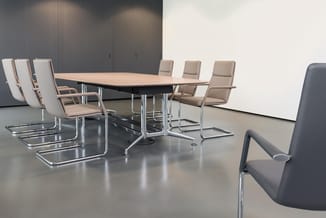 Moderne vergaderruimte met houten tafel, beige en grijze kantoorstoel met chromen frame, witte whiteboard en grijze geluidsab