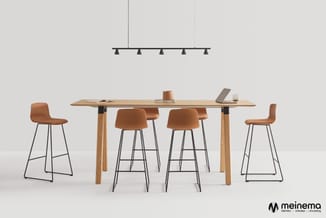 Houten vergadertafel met cognackleurige barstoel met metalen frame, zwarte hanglamp en laptopstandaard in moderne werkomgevin