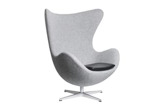Grijze fauteuil met organische vormen, zwart zitgedeelte en vierpoots aluminium voetsteun op witte achtergrond.