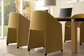 Gele akoestische stoelen op wielen rond houten tafel in kantoorruimte met grote ramen en herfstlandschap.