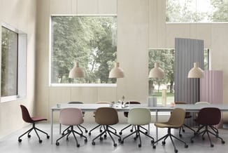 Vergaderruimte met lange tafel, zes gekleurde draaistoel in pasteltinten, vier hangende beige lampen, grote ramen met uitzich