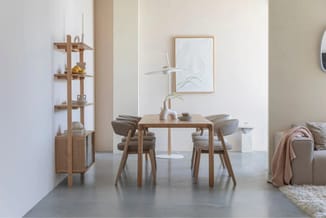 Houten eetkamer met rechthoekige tafel, twee stoelen met grijze stof, houten wandkast, staande plant en framed artwork op wit