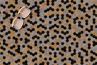 Twee roze stoelen op hexagonale tegelvloer in hout, grijs en zwart.