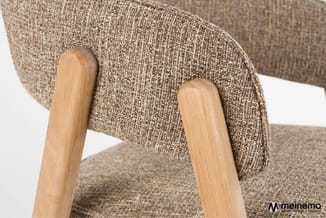 Beige stoelrug met geweven textiel en houten armleuningen in natuurtint, gedeeltelijk zichtbaar.
