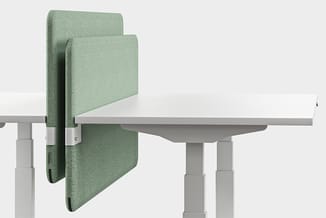 Groene akoestische schermen op grijze bureautafel, modulair opgesteld als geluidsisolatie voor werkplek.