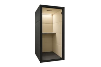 Zwarte akoestische belcel met beige binnenwanden, ingebouwde verlichting, werkblad en gesloten deur.