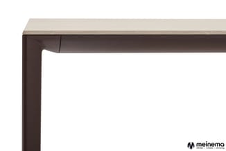 Kantoorbureau met donkerbruin metalen frame en lichtbeige houten blad, zijprofiel.