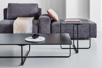 Grijze modulaire bank met roze kussen en beige plaid, zwarte salontafel en bijzettafel met marmeren blad in minimalistische w