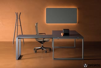 Modern kantoor met grijs bureau, zwarte bureaustoel, staande kapstok, grijze verlichte wandpaneel en oranje muren.