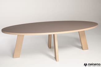 Ovale vergadertafel met grijsbruine tafelblad en licht houtkleurige houten poten, vrijstaand tegen lichte achtergrond.