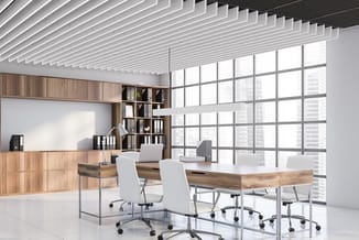 Modern kantoor met houten bureau, witte bureaustoel, houten kasten, lineair plafond en groot raampartij met stadsuitzicht.