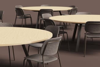 Drie ronde vergadertafels met licht houtfineer blad en zwarte poten, omgeven door grijze stoelen met armleuningen tegen bruin