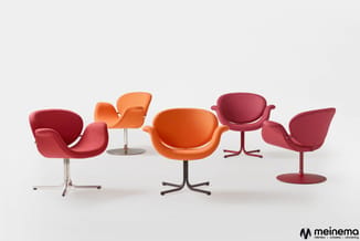 Vijf designstoelen in rood en oranje met ergonomische vormen op verschillende voetstukken tegen witte achtergrond. Meinema-lo