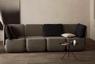 Modulaire bank met beige en zwarte stoffen elementen, afzonderlijke kussens, zijta bel en minimalistisch interieur.