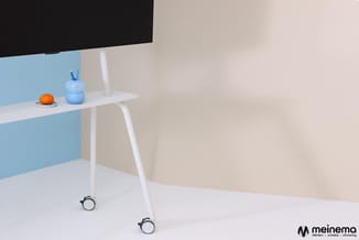 Wit bureau op wielen met blauwe scheidingswand, monitor, blauwe pennenbak en oranje object, in moderne kantoorruimte.