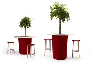 Twee rode cilindrische plantenbakken met houten tafelblad en bijbehorende houten barkrukken met rode zitting.