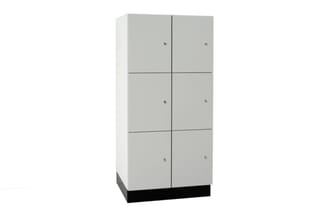 Grijze lockerkast met 6 compartimenten (2 kolommen, 3 rijen), zwarte voetplint, metalen sloten per vak.