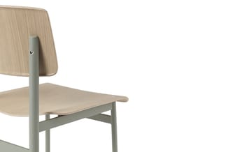 Houten stoel met licht grijs metalen frame en armsteunen, gezien vanaf de zijkant tegen witte achtergrond.