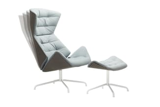 Grijze loungestoel met voetenbankje, wit stalen onderstel, gestoffeerde zitting met ergonomische rugleuning.