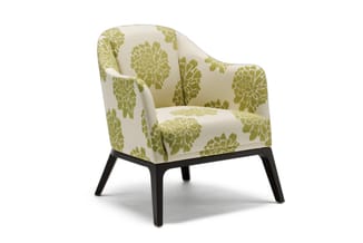 Fauteuil met groen bloempatroon op crème achtergrond, zwarte houten poten, moderne uitgevoerde armleuningen.