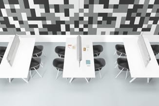 Bovenaanzicht kantoorruimte met witte bureaus, zwarte stoelen, grijze akoestische wandpanelen en geometrisch plafondpatroon i