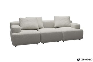 Grijze modulaire sofa met drie zitmodules, kussens en zwarte poten op witte achtergrond.