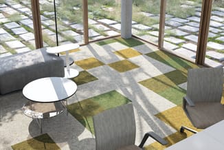 Moderne kantoorruimte met grijze stoelen, ronde witte tafel, kleurrijk tapijt in geel en groen, grote ramen met uitzicht op g