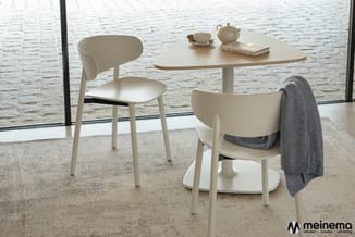 Witte ronde tafel met twee witte stoelen en een grijze plaid tegen zeelucht, decoratieve items op tafel, meinema logo.