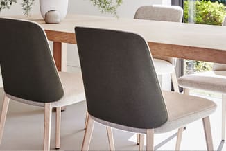 Eetkamerset met houten tafel en stoelen met grijze bekleding en lichte houten poten in moderne kantoorruimte.
