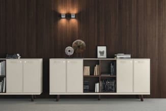 Witte kastencombinatie met donkerbruine houten achterwand, zwarte open vakken met boeken, wandverlichting en decoratieve obje