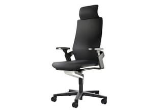 Zwarte ergonomische bureaustoel met netweave rug, verstelbare armleuningen en hoofdsteun, op wielenonderstel tegen witte acht