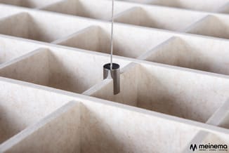 Metalen buisje aan staaldraad boven betonnen gridplafond met gaten, meinemo-logo rechtsonder.