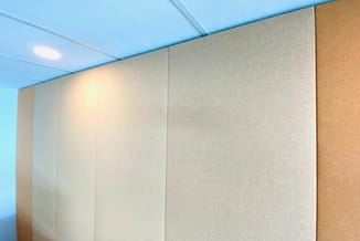 Akoestische wandpanelen in beige en taupe tinten tegen blauwe plafond in modern interieur.