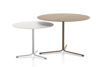 Twee ronde tafelbladen op dunne metalen poten. Links wit tafelblad met zilveren poot, rechts beige tafelblad met bruine poot.