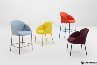 Vier moderne stoelen in verschillende kleuren: lichtblauwe barstoel, gele stoel, rode barstoel en bordeauxrode stoel op neutr