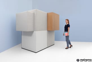 Vrouw naast modulair kantoormeubel met wit en naturel houten panelen in moderne ruimte met blauwe wand.