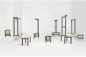 Collectie modulaire meubelen met zwarte metalen frames en houten zittingsvlakken, inclusief banken, tafels en wandgemonteerde