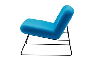 Blauwe fauteuil met afgeronde vormen en zwart stalen frame, zijkant zichtbaar tegen witte achtergrond.