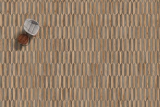 Houten visgraatpatroonvloer in beige- en grijstinten met twee ronde poefjes: een in grijs en een in donkerbruin hout.