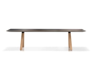 Lange vergadertafel met donkergrijs blad en houten poten in natuurlijke tint, frontale weergave tegen witte achtergrond.