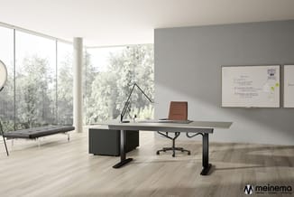 Modern kantoor met grijs bureau, bruine bureaustoel, zwarte bureaulamp, whiteboard, grijze lounge bank en grote raampartijen