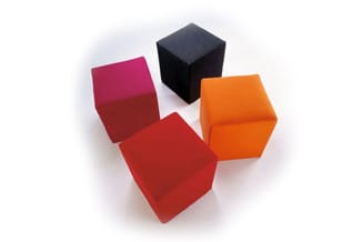 Vier zitblokken in rood, roze, oranje en zwart, gerangschikt in een cirkel op wit oppervlak.