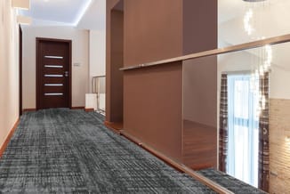 Moderne hallway met bruine wandpanelen, glazen afscheiding, grijze tapijttegels, donkerbruine deur met lichtstrepen en plafon