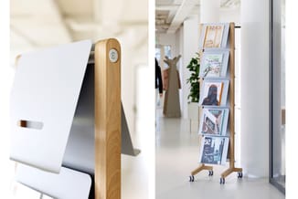 Links: Houten papierrolhouder met witte vulling in kantoor.
Rechts: Houten display standaard met wielen, gevuld met brochures