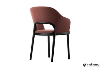 Loungestoel met terracottarood gestoffeerde zitting en rugleuning, zwart houten frame en armleuningen, tegen witte achtergron