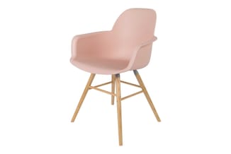 Roze kunststof armstoel met afgeronde rugleuning op houten spreidpoten, zijaanzicht.